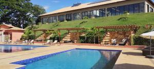 a hotel with a swimming pool in front of a building at Hotel Chalés Capitanias in Águas de Lindóia