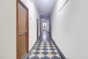 a hallway with a black and white checkered floor at SPOT ON New Balaji Residency in Hyderabad