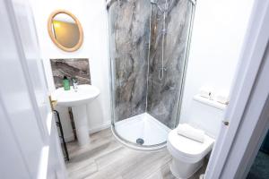 a bathroom with a shower and a toilet and a sink at Cosy 2-Bedroom Townhouse - FREE Parking in Stratford-upon-Avon