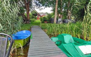 a green boat sitting on a wooden dock at 2 Bedroom Amazing Home In Wilcze in Wilcze