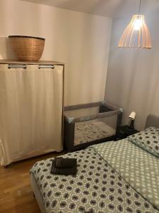 a bedroom with a bed and a basket and a lamp at Escale du parc in Longvic