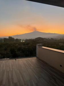 a balcony with a view of a mountain at sunset at Villetta Alcantara Apartment in Calatabiano