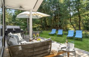 a patio with a couch and chairs and an umbrella at Four-Bedroom Holiday Home In Hojby in Højby