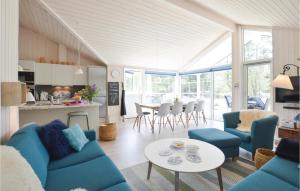 a living room with blue couches and a table at Four-Bedroom Holiday Home In Hojby in Højby