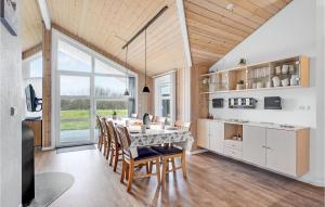 a kitchen with a table and chairs and a large window at Holiday Home Tarm 49 in Hemmet