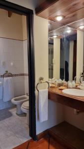 ein Badezimmer mit Waschbecken, Toilette und Spiegel in der Unterkunft Casa Calandria in Federación + 16 Fotos