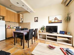 Il comprend une cuisine et un salon avec une table et une télévision. dans l'établissement Apartment Skopje Square, à Skopje