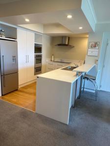a kitchen with a white counter and a refrigerator at Oxleys 406 3 bedroom Waterfront Apartment in Picton