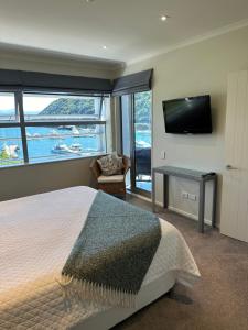 a bedroom with a bed and a flat screen tv at Oxleys 406 3 bedroom Waterfront Apartment in Picton