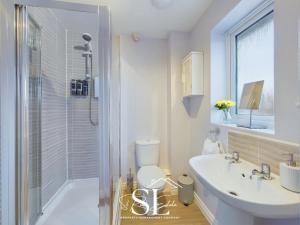 a bathroom with a toilet and a sink and a shower at Modern 3 bed Willenhall House in Willenhall