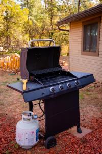 a barbecue grill with a laptop on top of it at Peaceful Pine Place Cabin in Pine