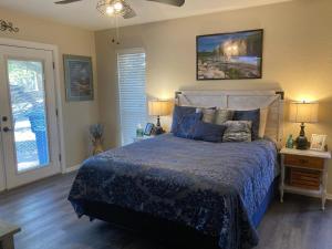 a bedroom with a bed with a blue comforter at Hidden Haven in Canyon Lake