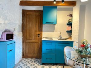 a kitchen with blue cabinets and a table with a microwave at De Alcalá al cielo Frida in Alcalá del Júcar