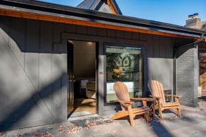奥克兰Cove Creek Lodge 215 Standard Double Queen Room的两把椅子坐在房子的庭院里