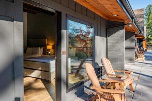 奥克兰Cove Creek Lodge 215 Standard Double Queen Room的两把椅子坐在房子前门廊上 更多4张照片