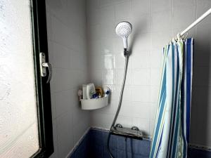 a shower head in a bathroom with a shower curtain at Romantic house in Sedella in Sedella