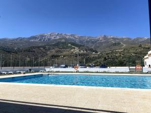 a large swimming pool with mountains in the background at Romantic house in Sedella in Sedella