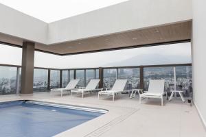 a pool on the floor of a building with chairs at Le Parc Residence Deluxe Suite in Quito