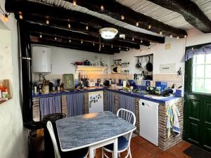 a kitchen with a table and a blue counter top at Romantic house in Sedella in Sedella