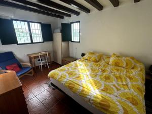 a bedroom with a bed with a yellow comforter at Romantic house in Sedella in Sedella