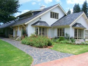 a white house with a stone walkway at Cedar Garden in Underberg
