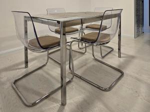 a glass table with two chairs and a laptop on it at La Nr 17 in Cernavodă
