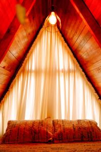 a bedroom with a canopy with a bed in front of a window at Chalés Recanto do Vale - TUCANO in Bom Jardim da Serra