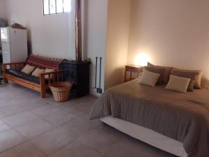 a bedroom with a bed and a couch and a stove at Casa en Villa Ventana in Villa Ventana