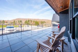 two chairs on a balcony with a view of a parking lot at Cove Creek Lodge 209 Standard Double Queen Room in Oakland +5 photos