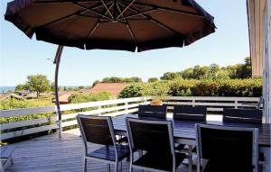 una mesa de madera con sillas y una sombrilla en una terraza en Holiday Home Hvedemarken Xii, en Hejls