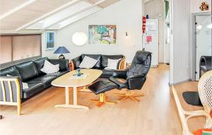 Una sala de estar con un sofá de cuero negro y una mesa. en Holiday Home Hvedemarken Xii, en Hejls 5 fotos más