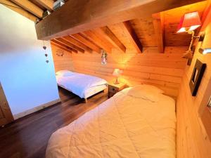 a bedroom with a bed in a wooden cabin at Chalet De Julie - Bel appartement traditionnel 4 pièces sur 2 niveau pour 6 personnes MAE-3734 in Saint-Martin-de-Belleville
