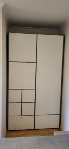 twee witte kastdeuren in een kamer bij Cosy Park Apartment, Free parking, Self-Check-In in Klaipėda +13 foto's