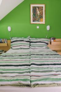 uma cama num quarto com uma parede verde em Apartments Sasha em Bled