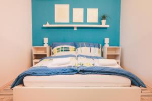 1 dormitorio con 1 cama con pared azul en Apartments Sasha, en Bled