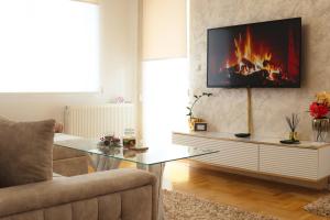 a living room with a glass table and a fireplace at Apartman Samsara in Sarajevo