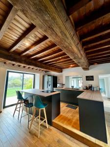 a kitchen with a table and chairs in a room at Maison des H, au bord de l'Etang in Canisy