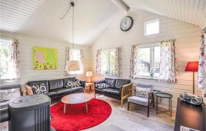 a living room with a couch and chairs and a clock at Cozy Home In Ebeltoft With Sauna in Ebeltoft