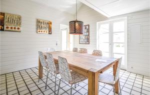 a dining room with a wooden table and chairs at Cozy Home In Ebeltoft With Sauna in Ebeltoft