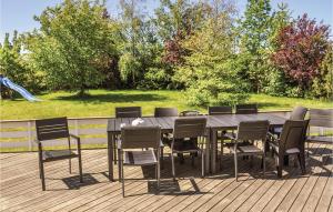 a wooden table and chairs on a deck at Holiday Home Strandparken Otterup Ix in Otterup