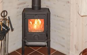 a stove with a fire in a room at Holiday Home Bork Hytteby Hemmet Denmark in Falen
