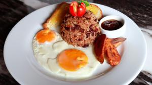 a plate of food with eggs and bacon and toast at Hotel Vista Bonita in Parrita