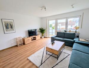 un soggiorno con un divano blu e una TV di Moderne und Gemütliche Stadtnahe Wohnung a Hassfurt