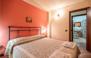 Un dormitorio con una cama con una pared naranja. en Nice Home In San Giovanni With Kitchen, en Montefiore dellʼAso