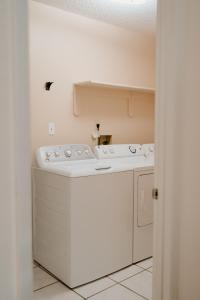 キシミーにあるLuxury Private Pool Villa near Disney with Fire Pit, Game Room & Moreの部屋にある白い洗濯機と乾燥機