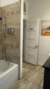 a bathroom with a white door and a tub at E-Hotel Des Grisons in Quebec City