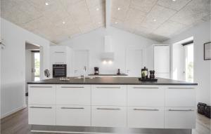 una cucina bianca con mobili bianchi e un lavello di Holiday Home Lakolk Rømø Denmark a Bolilmark
