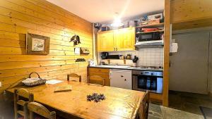 a kitchen with a wooden table and a kitchen with a stove at Résidence Le Belvedere - Chaleureux appartement T3 de 42 m²plein sud 4/6 personnes MAE-5231 in Pelvoux