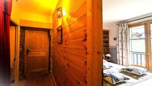a bedroom with a large wooden door and a bed at Résidence Le Belvedere - Chaleureux appartement T3 de 42 m²plein sud 4/6 personnes MAE-5231 in Pelvoux +1 photo