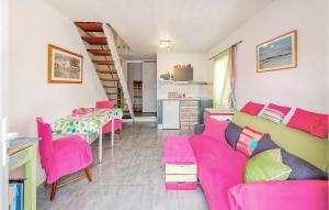 a living room with a pink couch and a table at Nice Home In Le Minihic-Sur-Rance in Le Minihic-sur-Rance